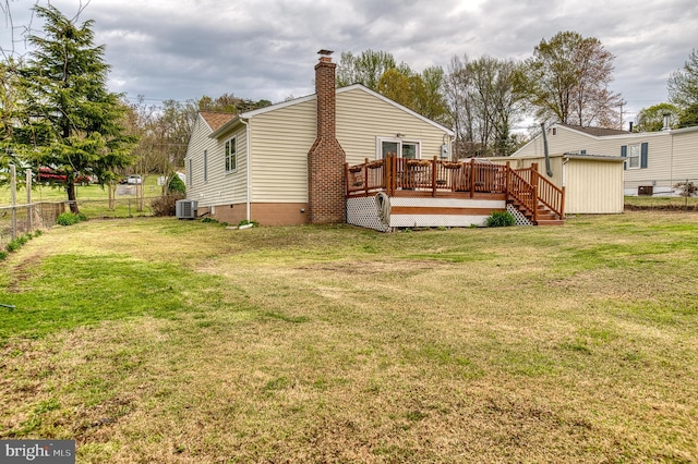 rear view of property with a yard, a wooden deck, fence, and a chimney