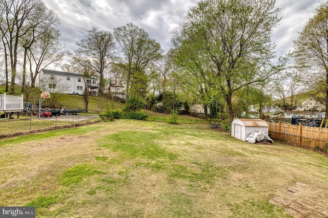 view of yard with a storage shed, an outdoor structure, and fence