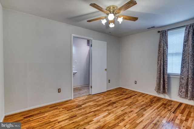 spare room featuring visible vents, baseboards, a ceiling fan, and wood finished floors