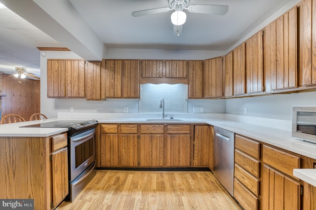 kitchen featuring brown cabinets, ceiling fan, and stainless steel appliances