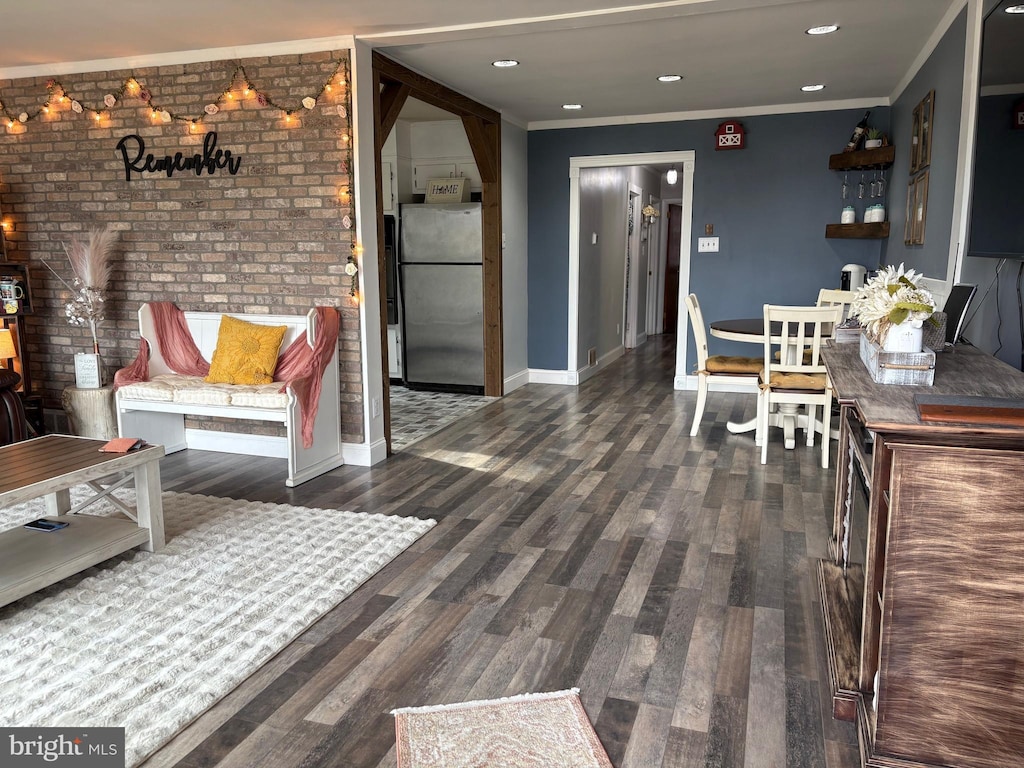 interior space with crown molding, dark wood-type flooring, and brick wall