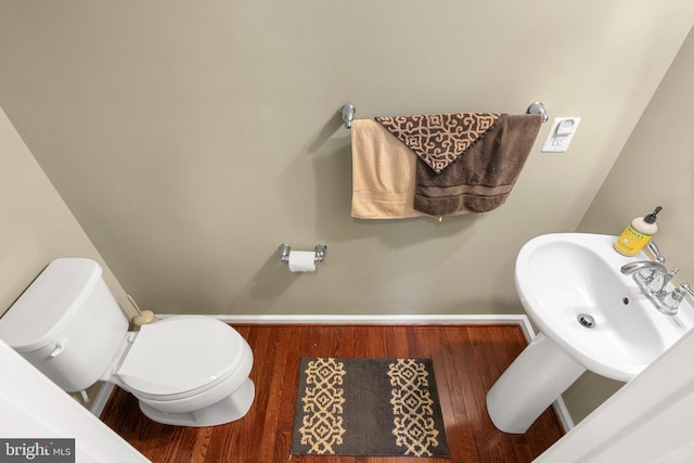 bathroom with hardwood / wood-style flooring, sink, and toilet