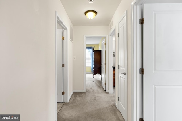 corridor featuring light colored carpet