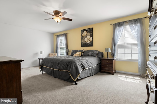 carpeted bedroom with ceiling fan and multiple windows