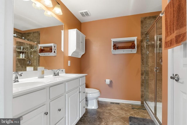 bathroom with an enclosed shower, vanity, tile patterned flooring, and toilet