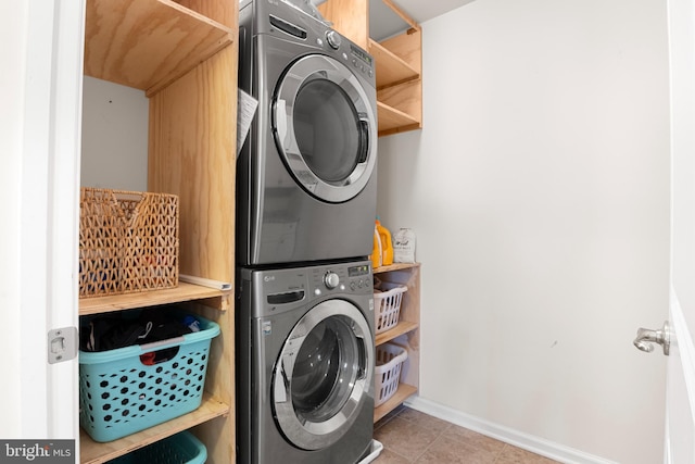 washroom featuring tile patterned flooring and stacked washer and dryer