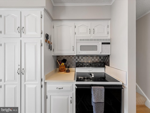 kitchen featuring white cabinetry, backsplash, and electric range