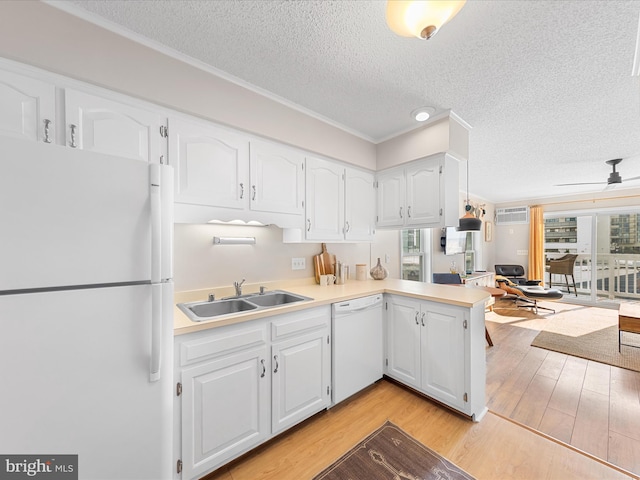 kitchen featuring sink, light hardwood / wood-style flooring, kitchen peninsula, white appliances, and white cabinets