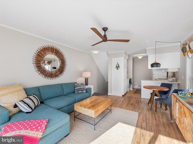 living room with ornamental molding, hardwood / wood-style floors, a textured ceiling, and ceiling fan