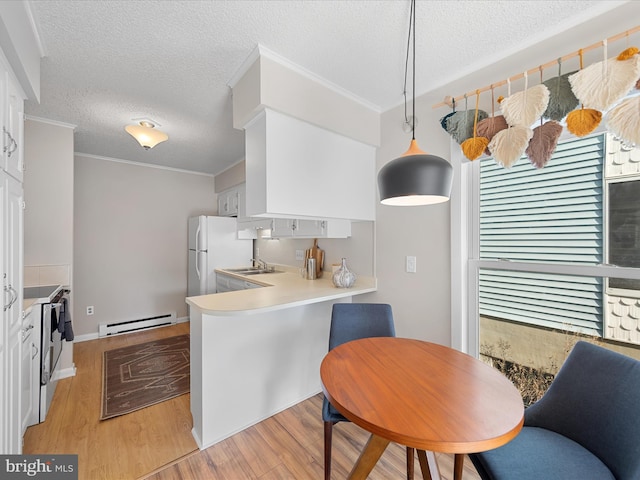 kitchen featuring white appliances, a baseboard heating unit, light hardwood / wood-style floors, white cabinets, and decorative light fixtures