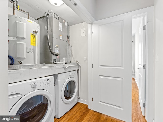 laundry room featuring separate washer and dryer, light hardwood / wood-style floors, and water heater