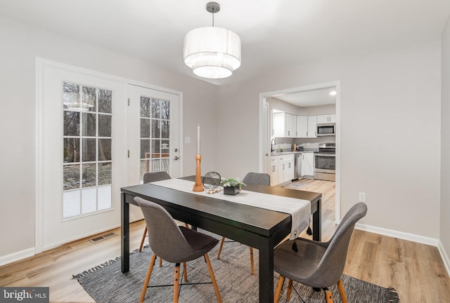 dining area with sink and light hardwood / wood-style flooring