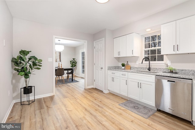 kitchen featuring white cabinetry, dishwasher, light stone countertops, and sink