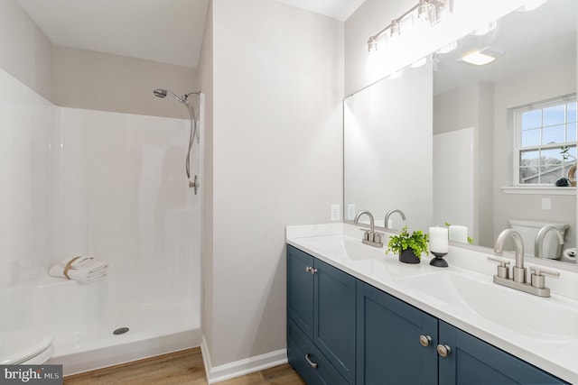 bathroom with vanity, hardwood / wood-style flooring, a shower, and toilet