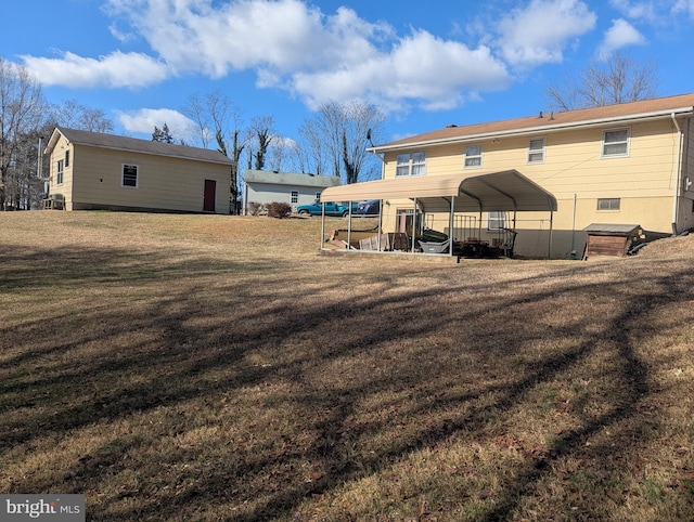 back of property with a carport and a lawn