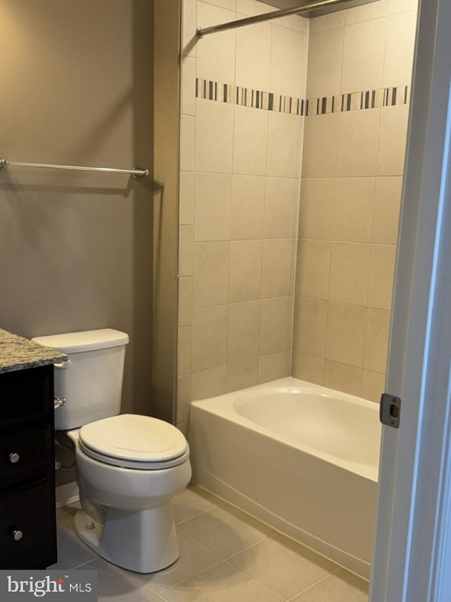 full bathroom featuring tile patterned flooring, vanity, tiled shower / bath, and toilet