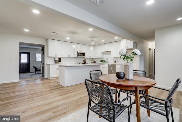 dining space featuring sink and light hardwood / wood-style flooring