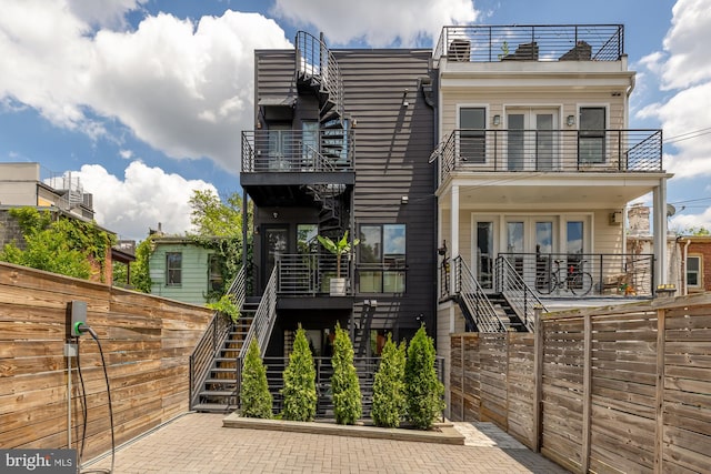 view of front facade featuring a patio area, french doors, and a balcony