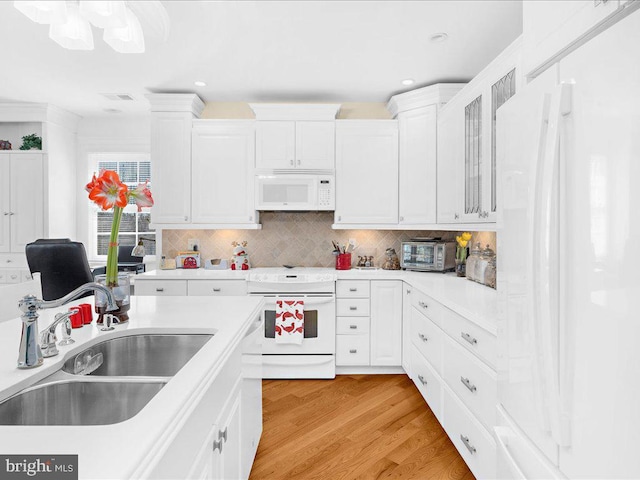 kitchen with light hardwood / wood-style flooring, white appliances, white cabinets, backsplash, and sink