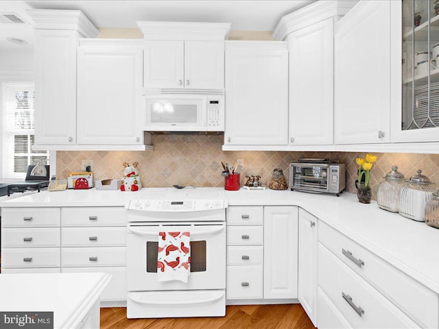 kitchen featuring decorative backsplash, white appliances, white cabinets, and light wood-type flooring