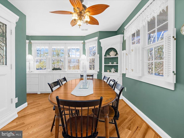 dining area with light wood-type flooring and ceiling fan