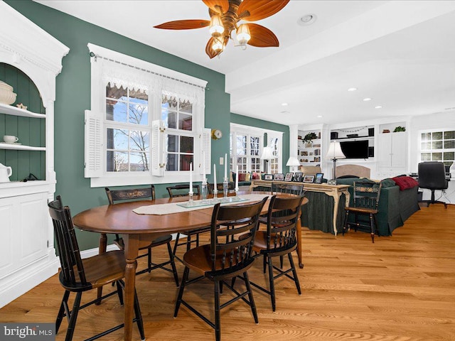 dining space with ceiling fan, light hardwood / wood-style flooring, and built in features