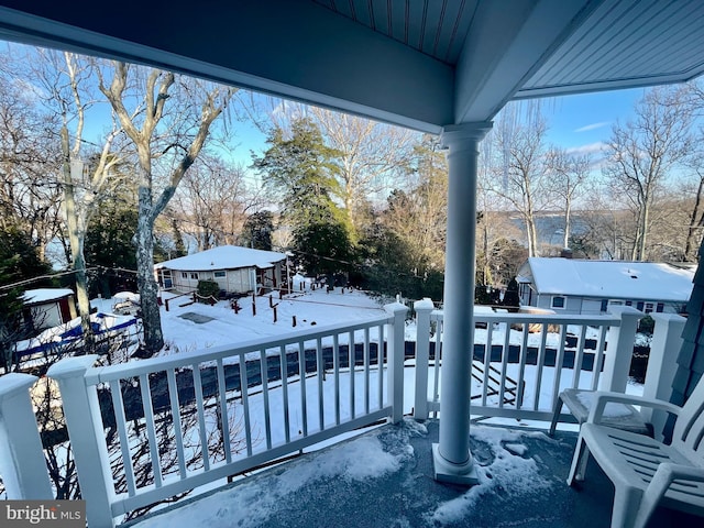 view of snow covered back of property