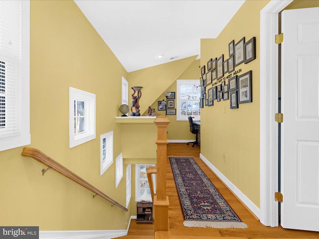 hall with hardwood / wood-style flooring and vaulted ceiling