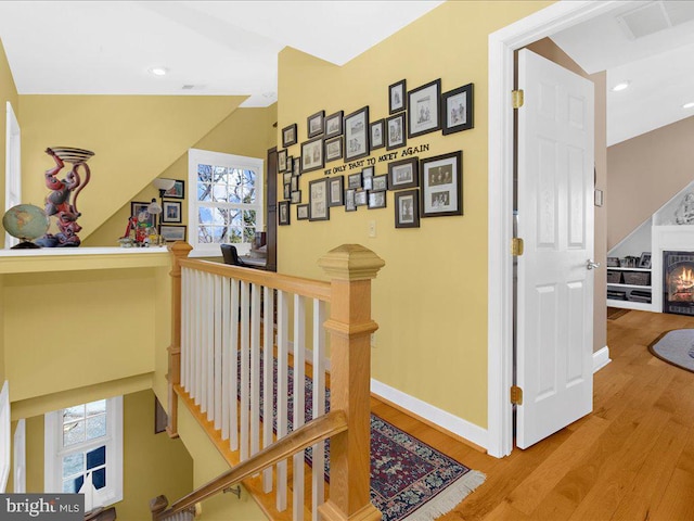 corridor featuring light hardwood / wood-style floors and lofted ceiling