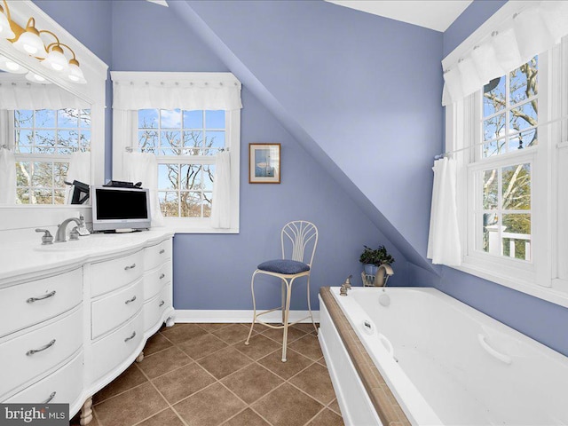 bathroom with vanity, tile patterned flooring, vaulted ceiling, and a relaxing tiled tub