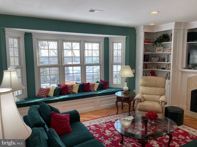 living area featuring light hardwood / wood-style floors and a high end fireplace