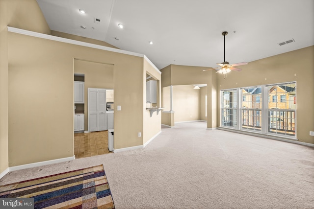 empty room with high vaulted ceiling, light carpet, and ceiling fan