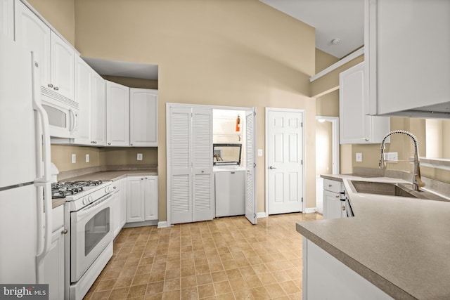 kitchen with white cabinetry, sink, white appliances, and high vaulted ceiling