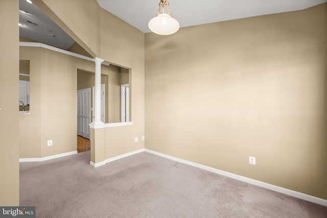 carpeted empty room featuring decorative columns