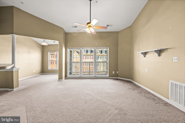 unfurnished living room with ceiling fan, carpet flooring, and high vaulted ceiling