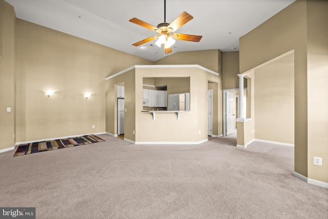 unfurnished living room with ceiling fan, light carpet, and high vaulted ceiling