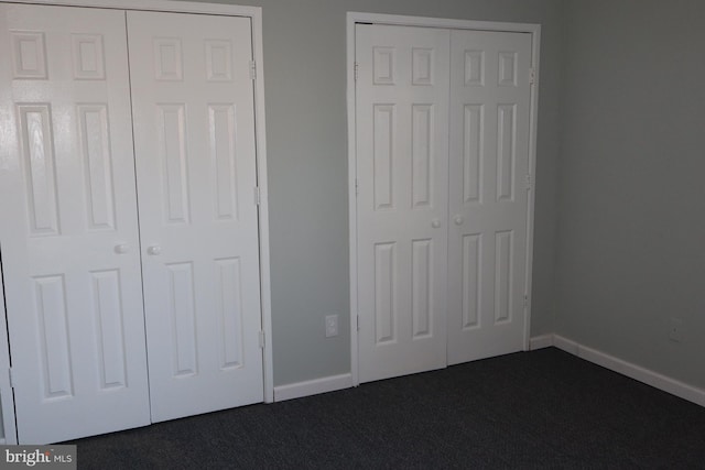 unfurnished bedroom with dark colored carpet