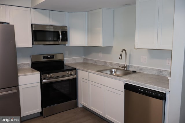 kitchen featuring appliances with stainless steel finishes, sink, and white cabinets