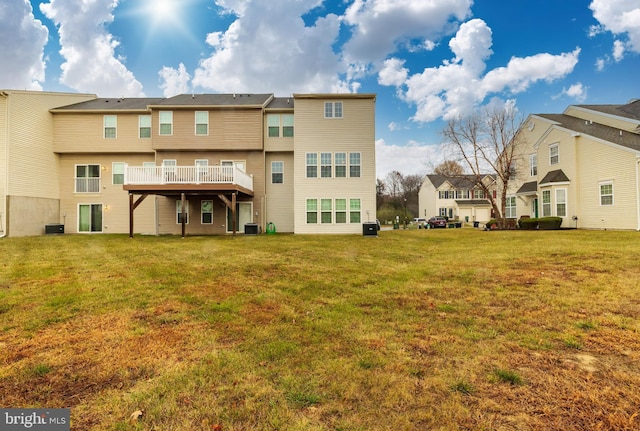 back of property featuring cooling unit and a lawn