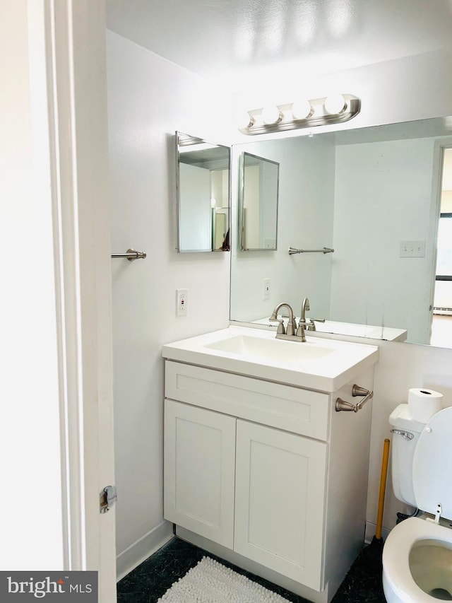 bathroom featuring vanity and toilet