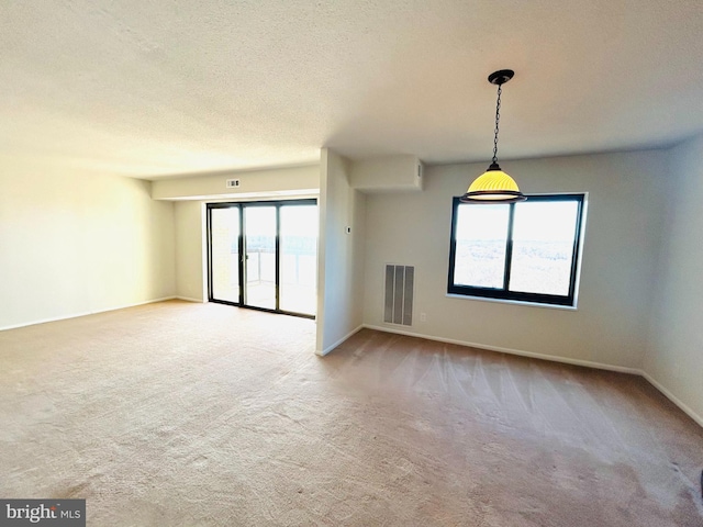 carpeted empty room featuring a textured ceiling