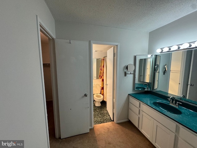 bathroom featuring vanity, toilet, and a textured ceiling