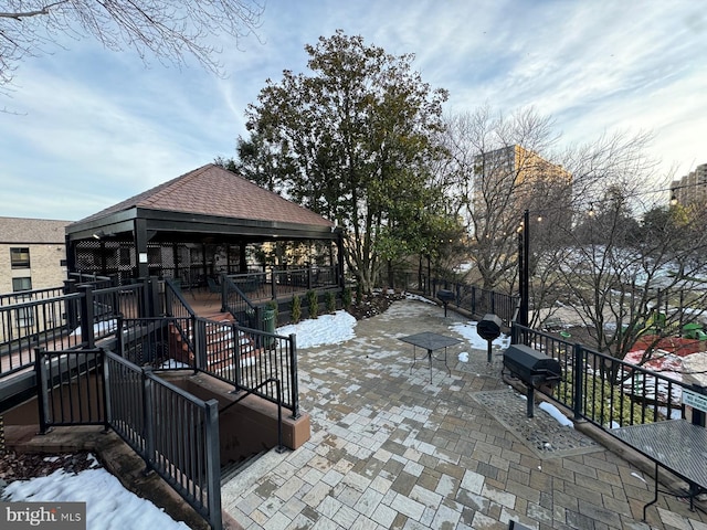 snow covered patio with a grill and a gazebo