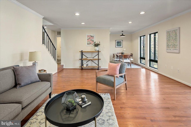 living room with light wood-type flooring and ornamental molding