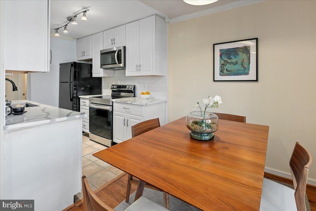 kitchen with sink, stainless steel appliances, light stone countertops, and white cabinets