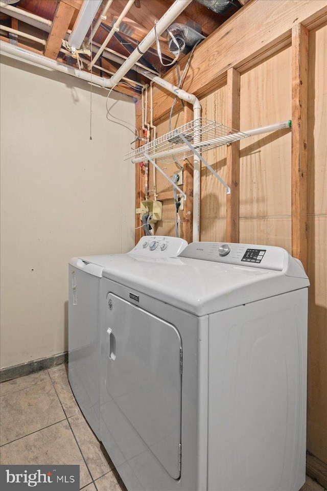 washroom featuring washing machine and dryer and light tile patterned floors