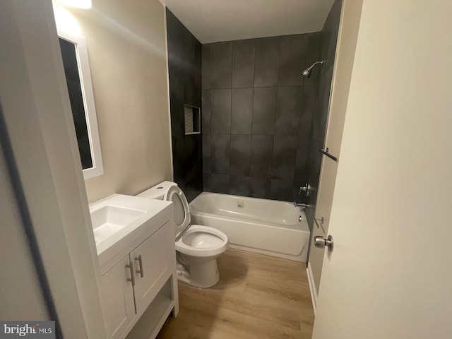 full bathroom with tiled shower / bath combo, vanity, toilet, and hardwood / wood-style floors