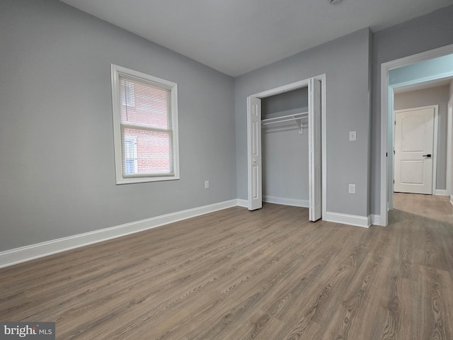 unfurnished bedroom featuring light hardwood / wood-style flooring and a closet