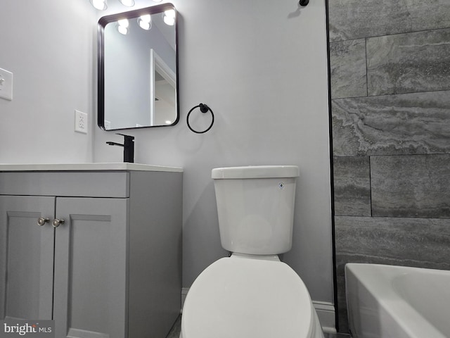 bathroom with vanity, toilet, and a bath