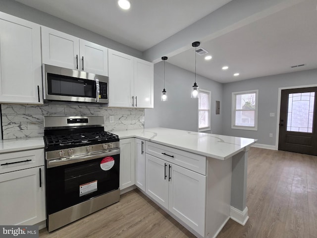 kitchen with white cabinetry, stainless steel appliances, kitchen peninsula, and light hardwood / wood-style floors